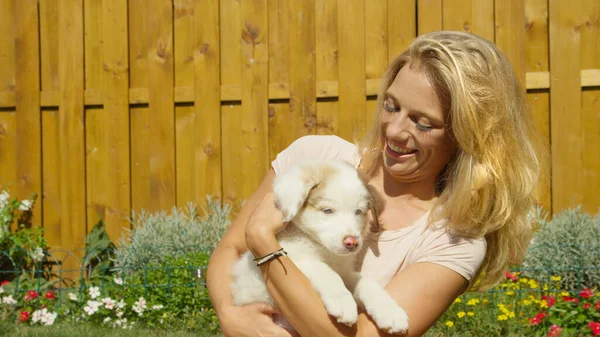 CERRAR: Mujer joven que se divierte acurrucándose con su adorable cachorro en un día soleado. — Foto de Stock