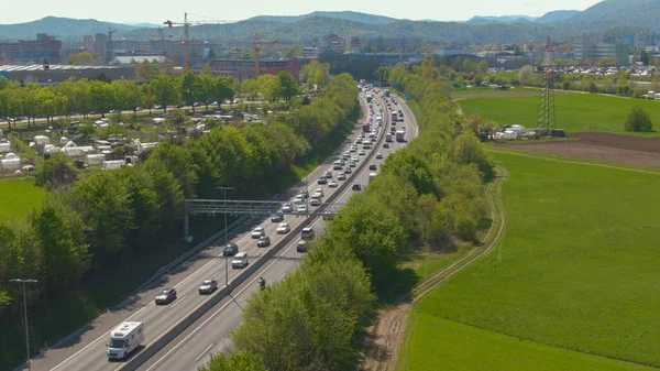 AERIAL: Innumerables coches y camiones conducen por la carretera durante la hora punta —  Fotos de Stock