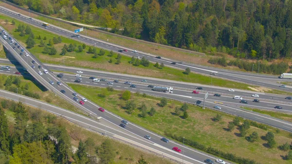 AERIAL: Talloze voertuigen rijden in de zomer op en neer op het drukke wegennet. — Stockfoto
