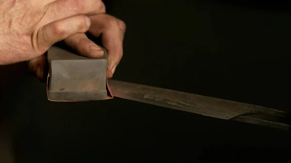 가까이 서: 전통적 인 칼 날을 날카롭게 깎고 작업하는 남자 장인. — 스톡 사진