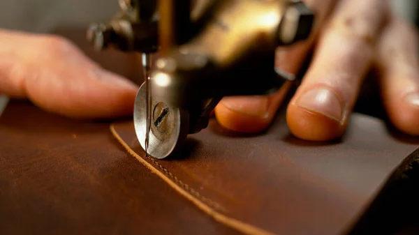 MACRO: Macchina da cucire che crea una cucitura perfetta lungo un pezzo di pelle marrone. — Foto Stock