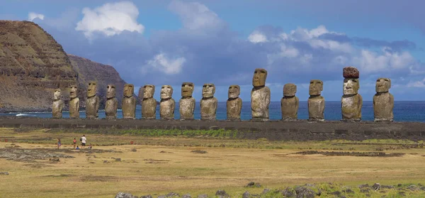 Toeristische familie observeert de spectaculaire moai beelden aan de kust van Paaseiland. — Stockfoto