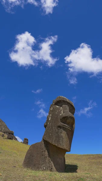 VERTICAL: Białe chmury dryfują nad dwoma dużymi posągami moai na odległej egzotycznej wyspie. — Zdjęcie stockowe