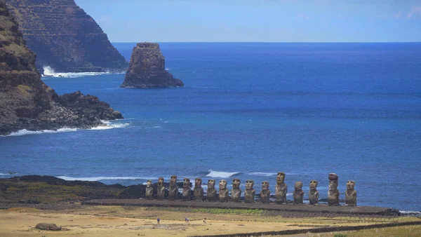 AERIAL: Malutcy turyści robiący zdjęcia linii moai posągów nad oceanem. — Zdjęcie stockowe