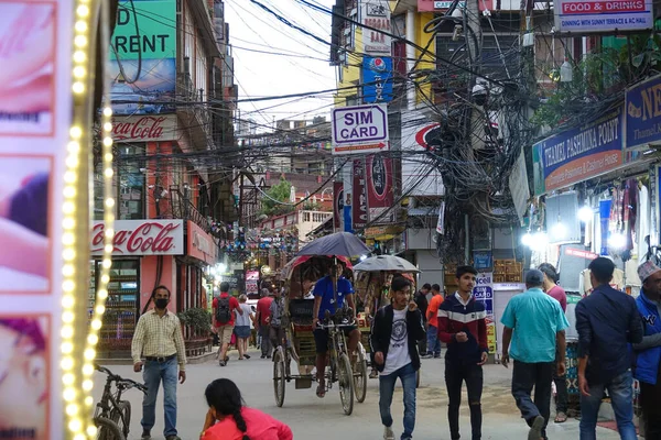 Bike taxi rides along a crowded street and past tourist shops selling souvenirs. — Stock Photo, Image