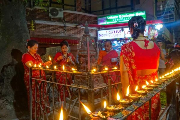 CHIUDI buddista raccogliere e accendere candele ad olio intorno a una struttura buddista — Foto Stock