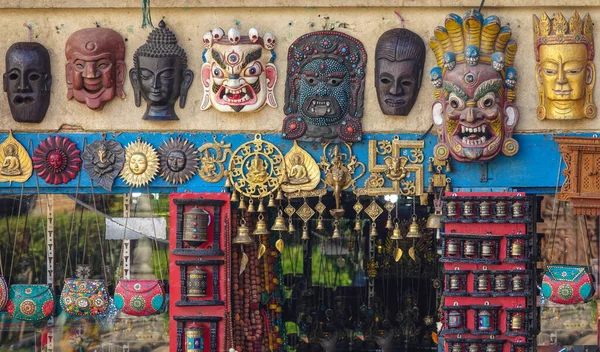 Κοντινό πλάνο: Παραδοσιακές ξύλινες βουδιστικές μάσκες κρέμονται στον τοίχο ενός καταστήματος με σουβενίρ. — Φωτογραφία Αρχείου