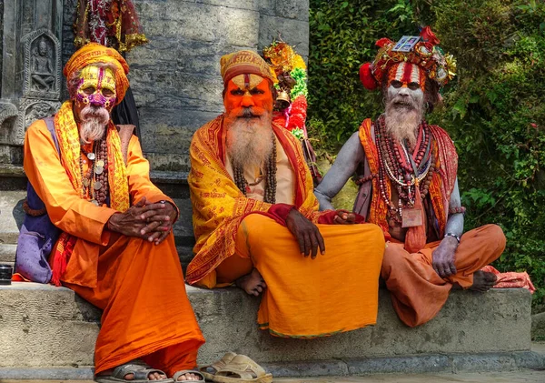 RETRATO: Iogis fascinantes no Templo Pashupatinath sentados em uma borda de concreto. — Fotografia de Stock