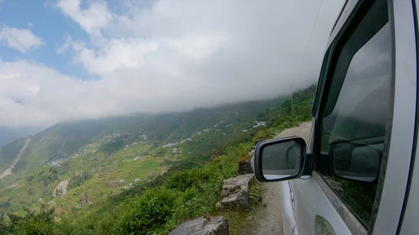 POV: Jízda po okraji strašidelné hrbolaté silnice s výhledem na vesnici v Nepálu. — Stock fotografie