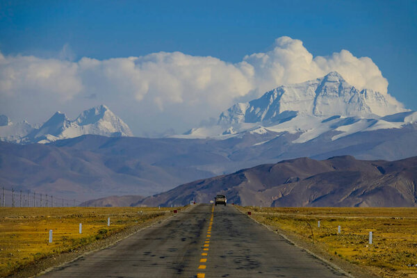 Pick up truck disappears in the distance as it travels towards Mount Everest