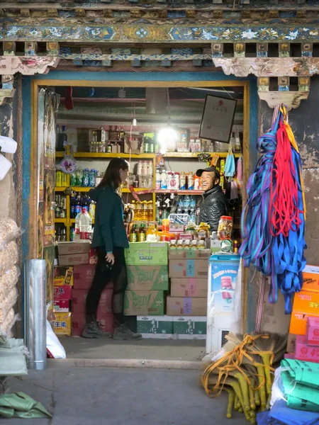 FECHAR UP Mulher fala com um homem que vende mantimentos em uma loja de conveniência em Tingri — Fotografia de Stock