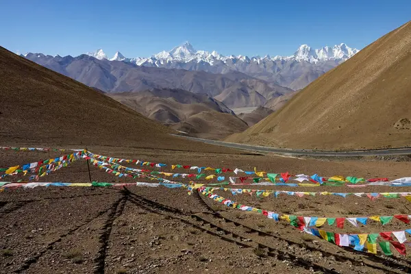 Malowniczy widok odległego zaśnieżonego Everestu i kolorowe flagi trzepoczące w silnym wietrze. — Zdjęcie stockowe