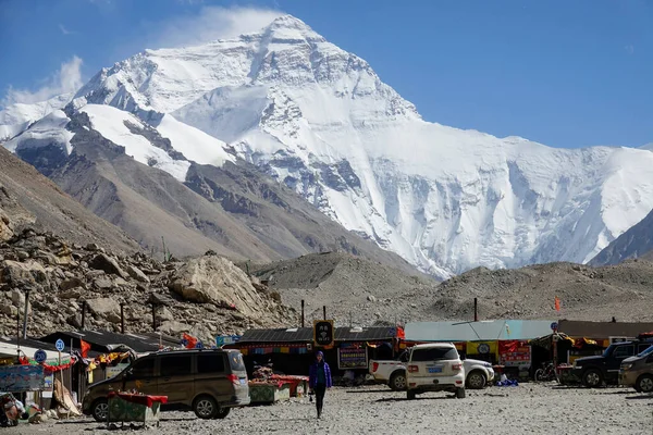 Młoda kaukaska kobieta przechadza się po parkingu pod zaśnieżonym Mount Everest. — Zdjęcie stockowe