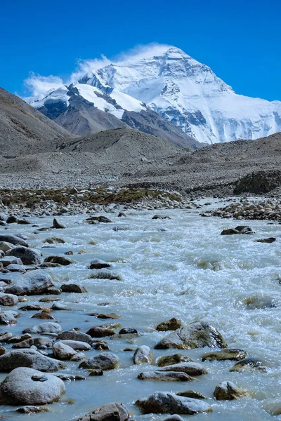 WERTYCZNE: Brudny strumień przepływa przez skaliste podnóże zaśnieżonego Mount Everest. — Zdjęcie stockowe