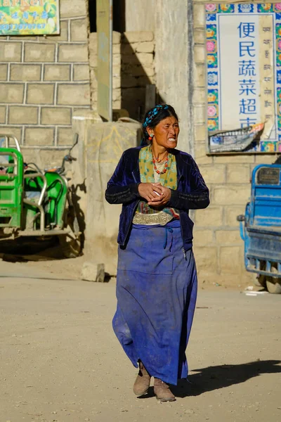 Κοντινό πλάνο: Θιβετιανή γυναίκα διασχίζει τον άδειο δρόμο και κοιτάζει γύρω από το χωριό — Φωτογραφία Αρχείου