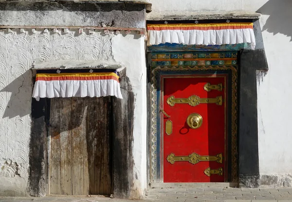 CLOSE UP: Beautiful shot of a brown wooden door next to a red and gilded door. — 图库照片