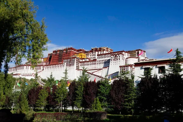 Szcenírozott kilátás az ősi Potala palota tetején egy tibeti hegy és egy szép park. — Stock Fotó