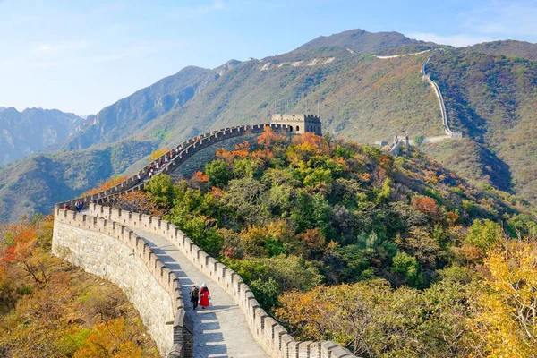 Los turistas caminan a lo largo de la antigua Gran Muralla de China en un día soleado de otoño. — Foto de Stock