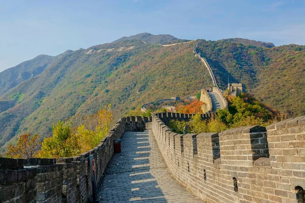 Los viajeros caminan por la pasarela en la parte superior de la famosa Gran Muralla de China en el día soleado — Foto de Stock
