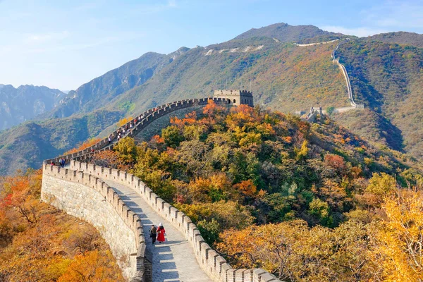 Two unrecognizable tourists walk along the walkway atop the Great Wall of China. — Stock Photo, Image