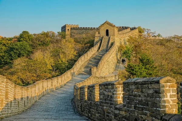 Dos turistas a lo lejos suben un tramo de escaleras caminan a lo largo de la Gran Muralla — Foto de Stock