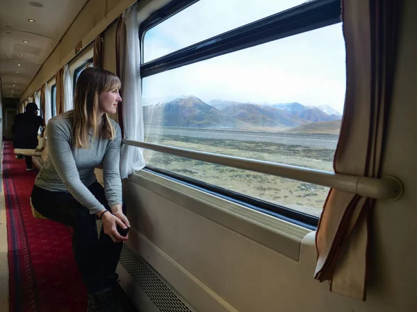 CLOSE UP: Traveler daydreams while looking through window train crossing Tibet — Stock Photo, Image