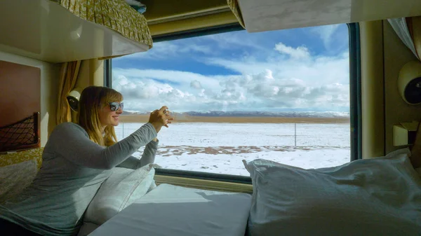 FERMETURE : Femme prenant des photos du paysage tibétain enneigé pendant le trajet en train. — Photo