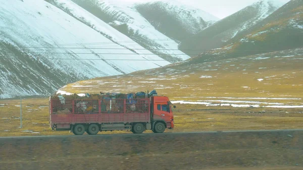 Rode vrachtwagen vervoert schroot langs een schilderachtige weg in de Himalaya. — Stockfoto