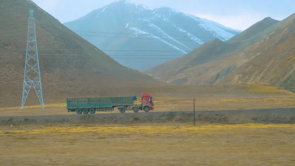 Cinematografische opname van een oude vrachtwagen die vracht vervoert door Tibet op een bewolkte dag — Stockfoto
