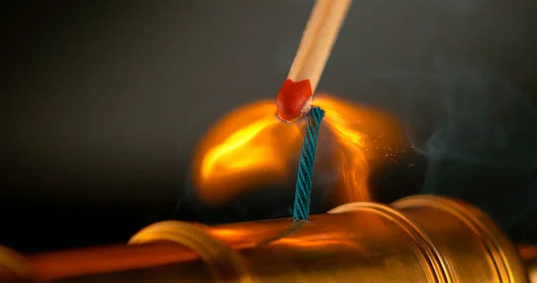MACRO: Égő gyufa világít a rövid kék biztosíték egy miniatűr sárgaréz ágyú. — Stock Fotó