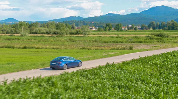 AERIAL: Fotografía cinematográfica de un nuevo Tesla Model 3 que se conduce por una carretera pintoresca. — Foto de Stock