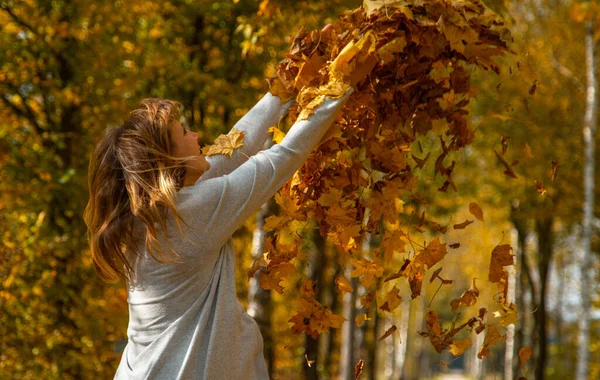 ZAMKNIJ: Kobieta wyciąga ręce po wyrzuceniu sterty liści w powietrze. — Zdjęcie stockowe