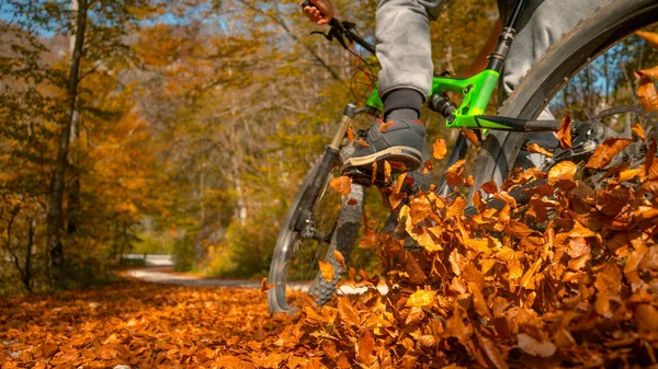 CERRAR: Hombre irreconocible monta bicicleta de montaña en una pila de hojas caídas —  Fotos de Stock