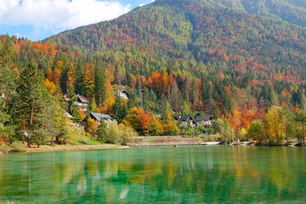 Vista mozzafiato sulle case vacanze fronte lago nascoste nei boschi colorati autunnali — Foto Stock