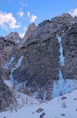Dağcılar donmuş bir nehrin altında toplanıp dağdan aşağı iniyorlar.