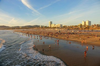 Turistler gün batımını izlemek için Santa Monica 'nın kumlu sahillerinde toplandılar..
