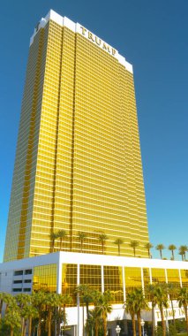 Vegas 'taki devasa yaldızlı Trump Oteli, bereketli palmiye ağaçlarının üzerindeki kuleler..