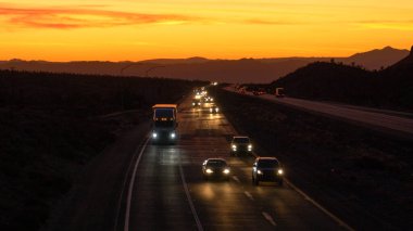 Mojave otobanında alacakaranlıkta gezginler ve kamyoncular araba kullanıyor..