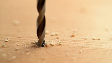 Keskin metal parçasının ahşap bir tahtaya saplanmasının detaylı yakın çekim görüntüsü..