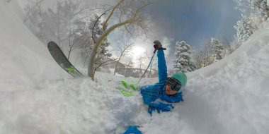 SELFIE: Funny shot of a skier crashing in deep powder snow while tree skiing. clipart