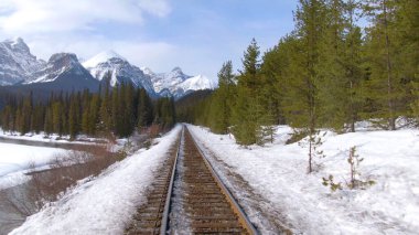 Bir trenle donmuş bir nehir boyunca ve karlı dağlara doğru gidiyorum.