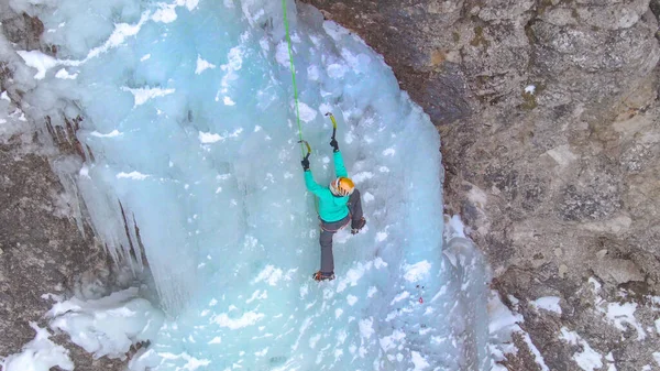 DRONE: Donna coraggiosa sale su una bella cascata ghiacciata nelle Alpi. — Foto Stock