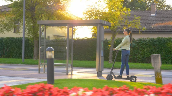 Mujer blanca urbana va a dar un paseo divertido a través de los suburbios en el nuevo e-scooter —  Fotos de Stock