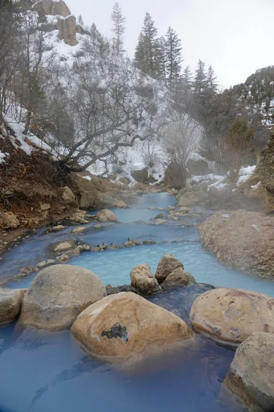 VERTICAL: Prachtige lichtblauwe bronwater cascades van de ene vijver naar de andere — Stockfoto