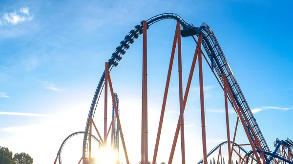 LENS FLARE: Golden sunbeams shine on the massive loop of a roller coaster ride — Stock Photo, Image