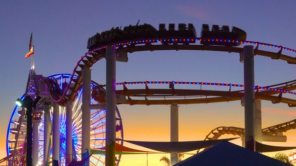 SILHOUETTE: Bela vista do parque de diversões no cais de Santa Monica ao pôr-do-sol. — Fotografia de Stock
