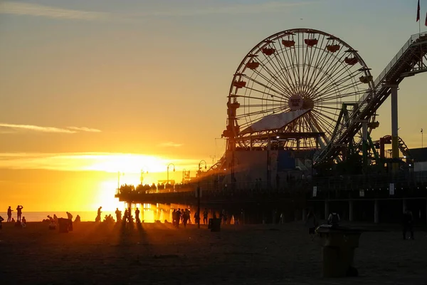 LENS FLARE: Lindo tiro de raios de sol dourados iluminando Santa Monica Pier. — Fotografia de Stock