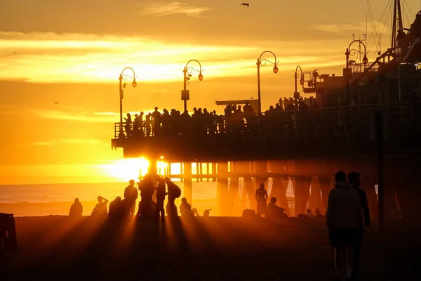 FECHAR-SE: Turistas visitam a famosa praia de Santa Monica e cais ao pôr do sol. — Fotografia de Stock