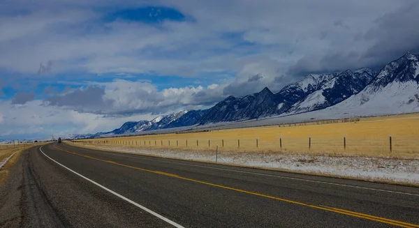 Auto ver in de verte rijdt langs de schilderachtige snelweg die loopt over Montana — Stockfoto