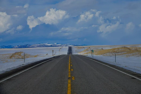 Rechte asfaltweg loopt langs prachtige gouden weiden op het platteland van Montana. — Stockfoto